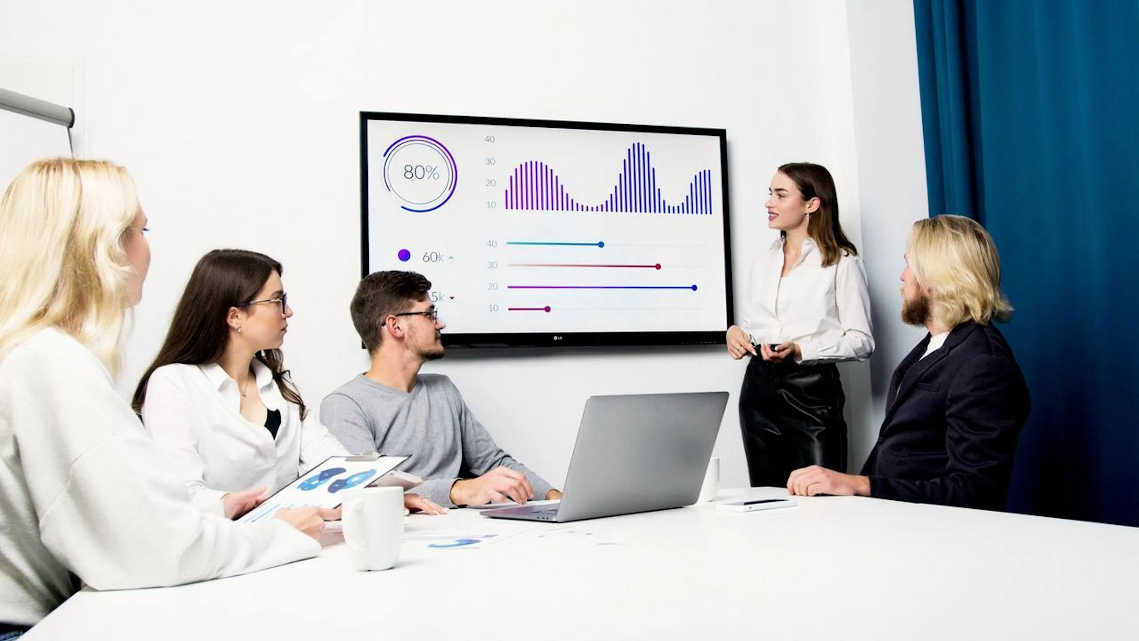 equipe em reunião analisando dados em telas digitais