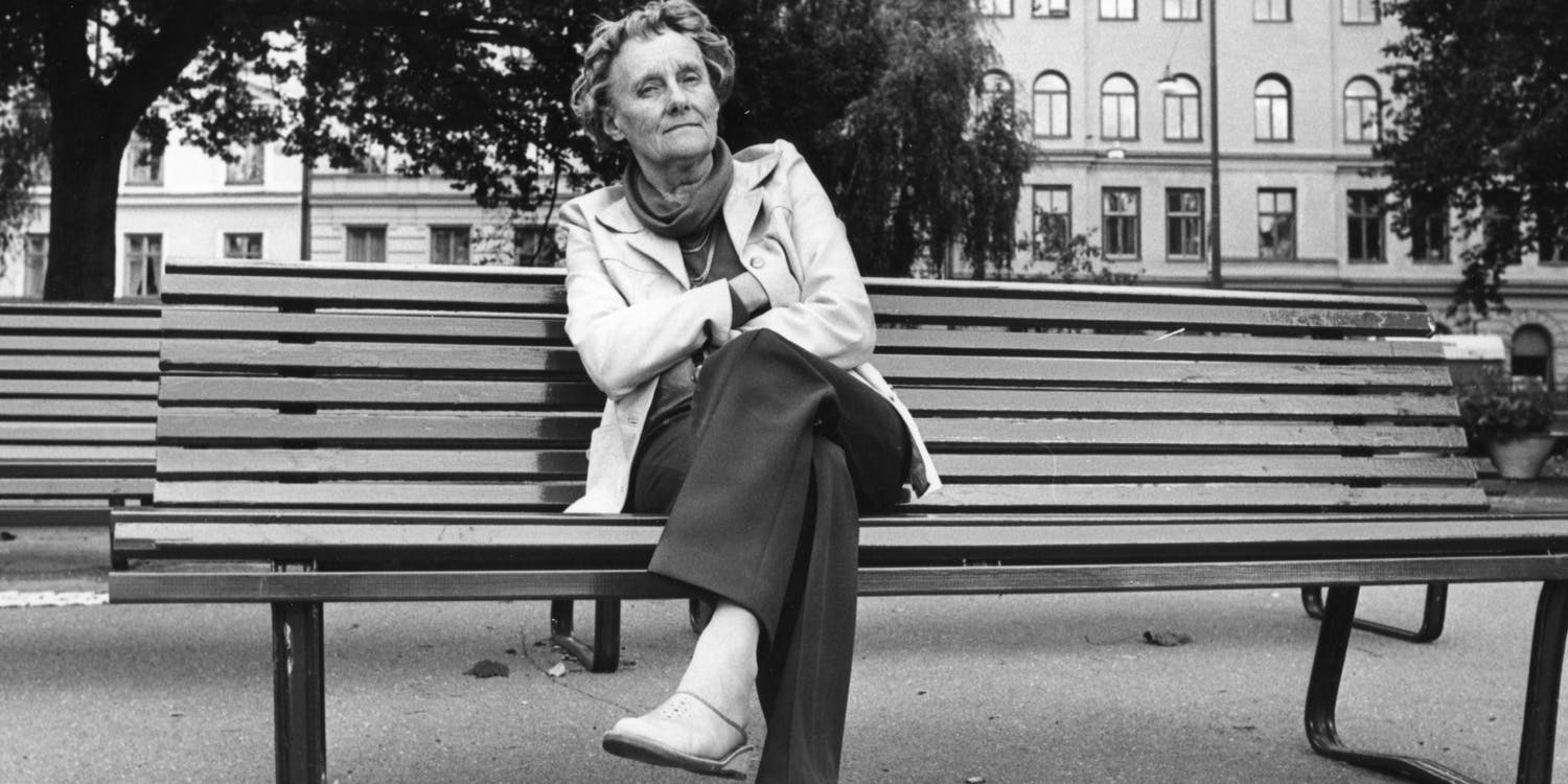 Astrid Lindgren sitter på bänk