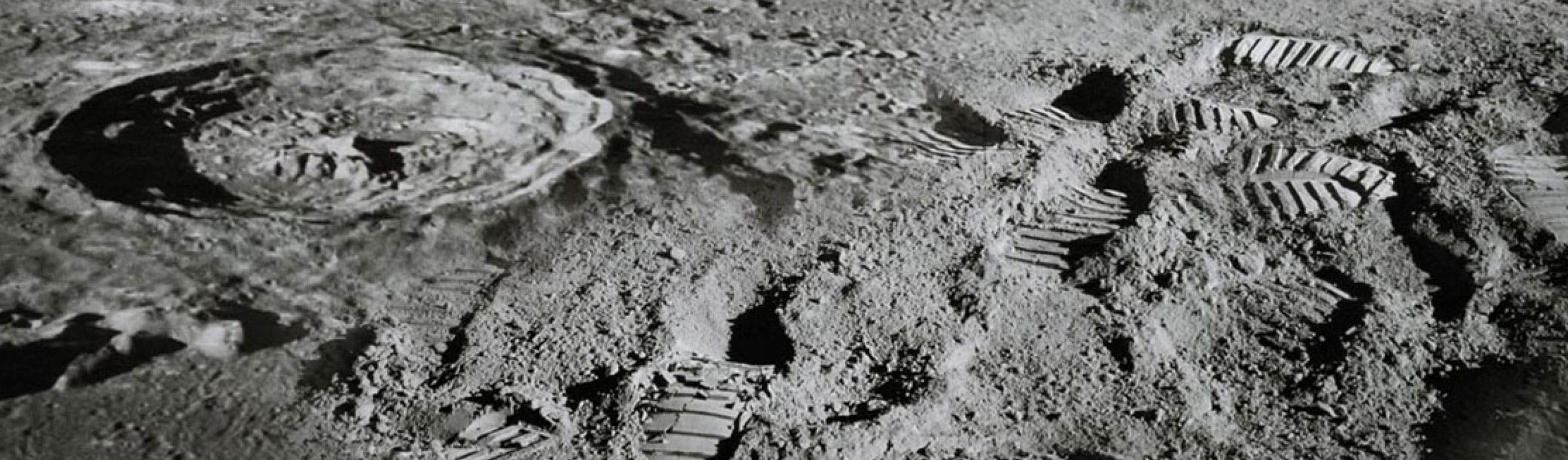 Footprints next to a moon crater.
