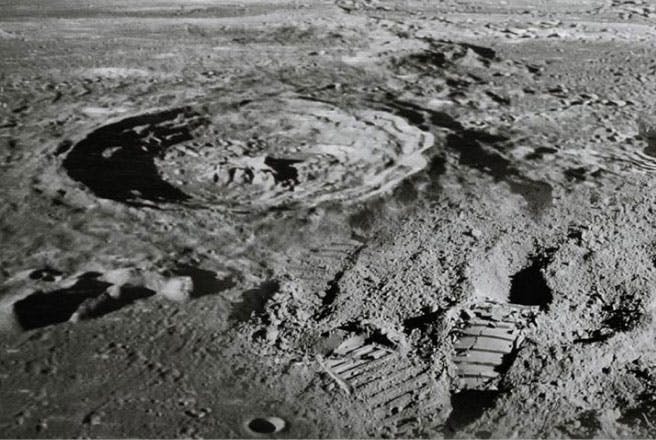 Footprints next to a moon crater.