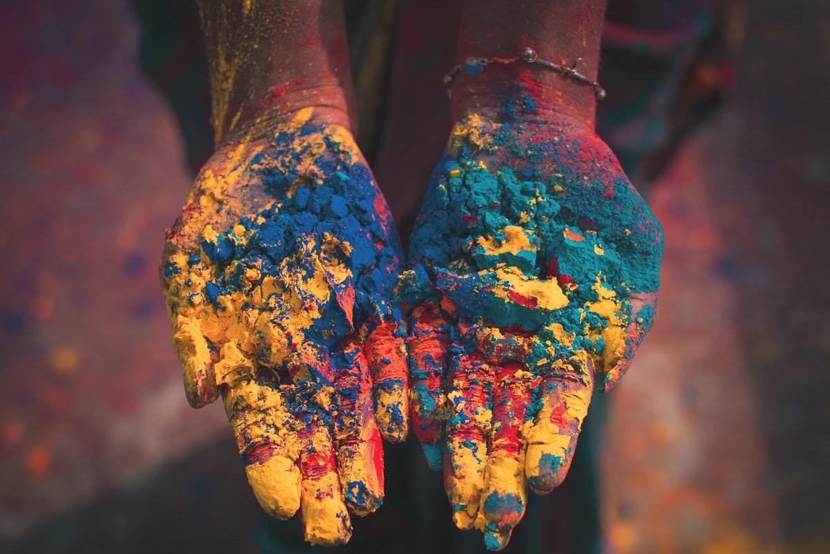 Atelier Unes - Mains tenant des poudres de couleurs qui servent de teintures pour les vêtements