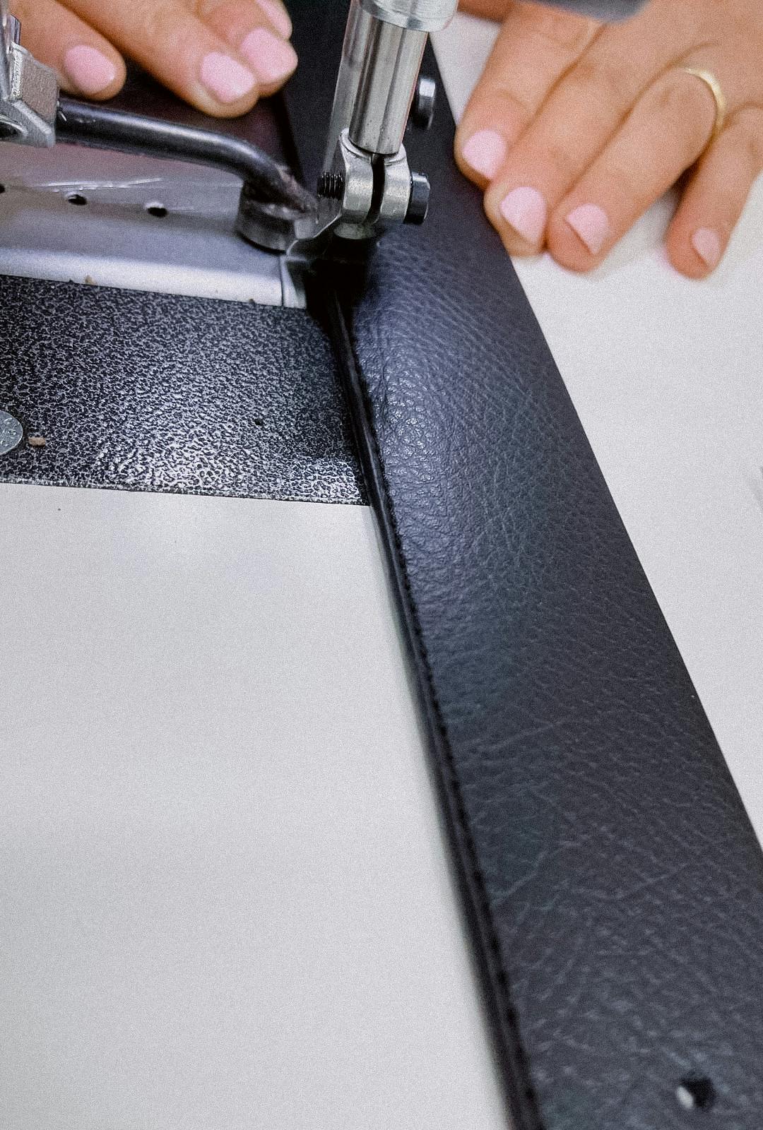 gros plan sur une ceinture en train d'être cousue à la machine à coudre atelier unes