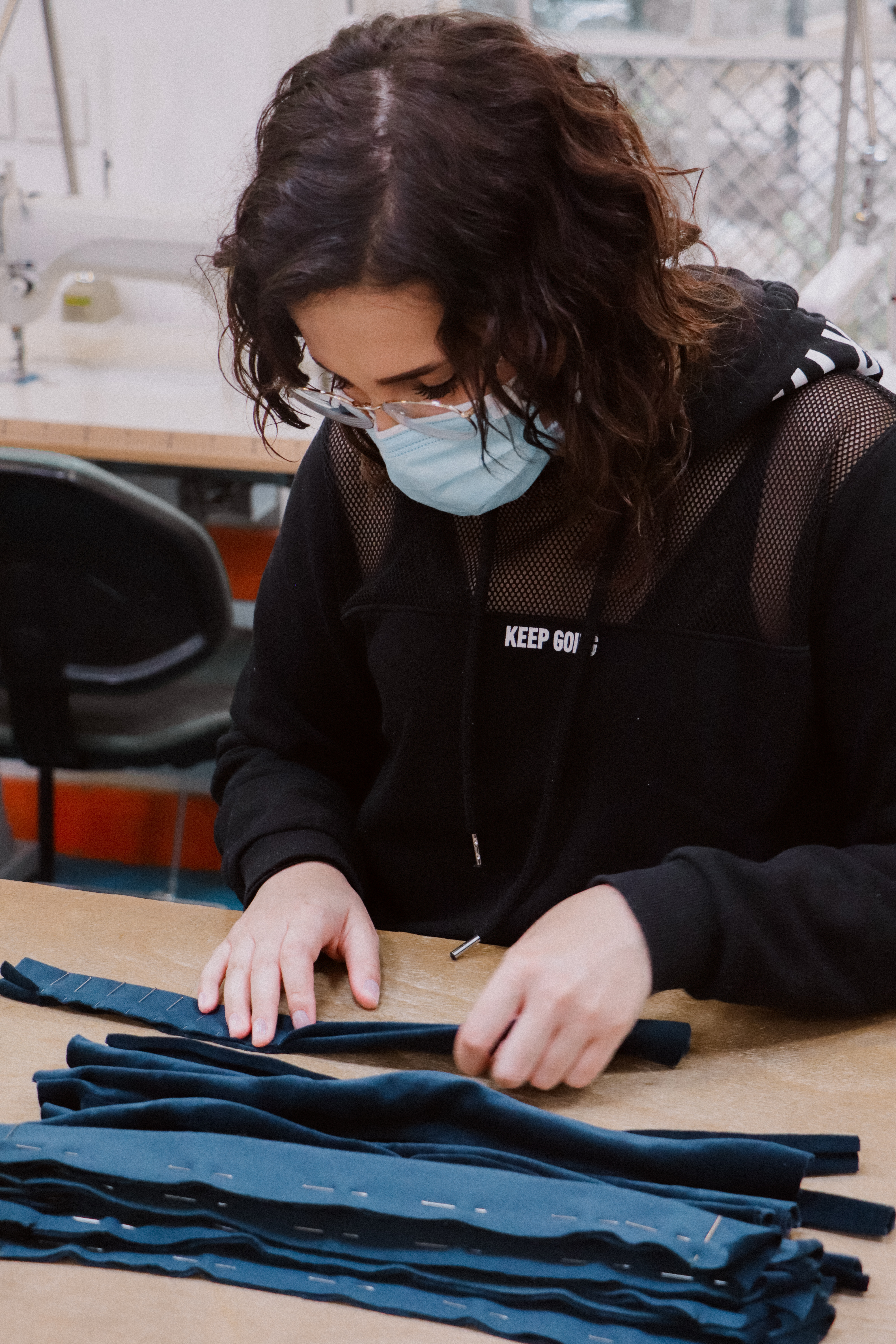 femme en train de coudre un elastique chouchou pour cheveux dans un atelier de couture atelier unes