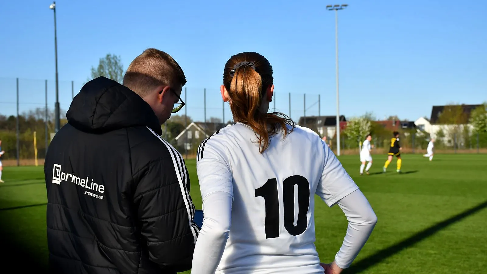 Trainer Sebastian Heuser bespricht an der Seitenlinie eine Szene auf dem Tablet mit einer Spielerin der SVKT 07 Minden