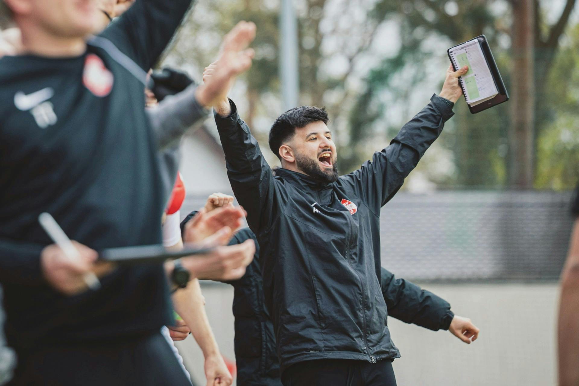 Alex Naimoli freut sich an der Seitenlinie mit einem Taktizettel in der Hand über ein Tor.