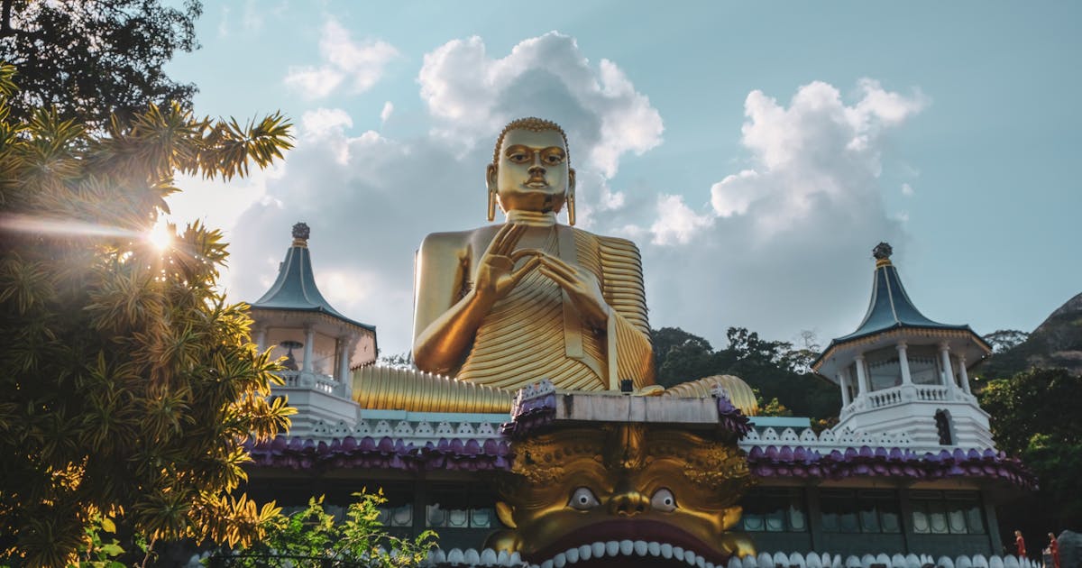 Sunset over the golden Buddha statue in Sri Lanka