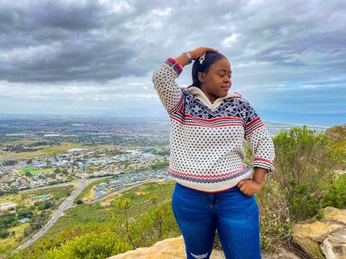 A picture of Mable posing on top of a mountain at cape town
