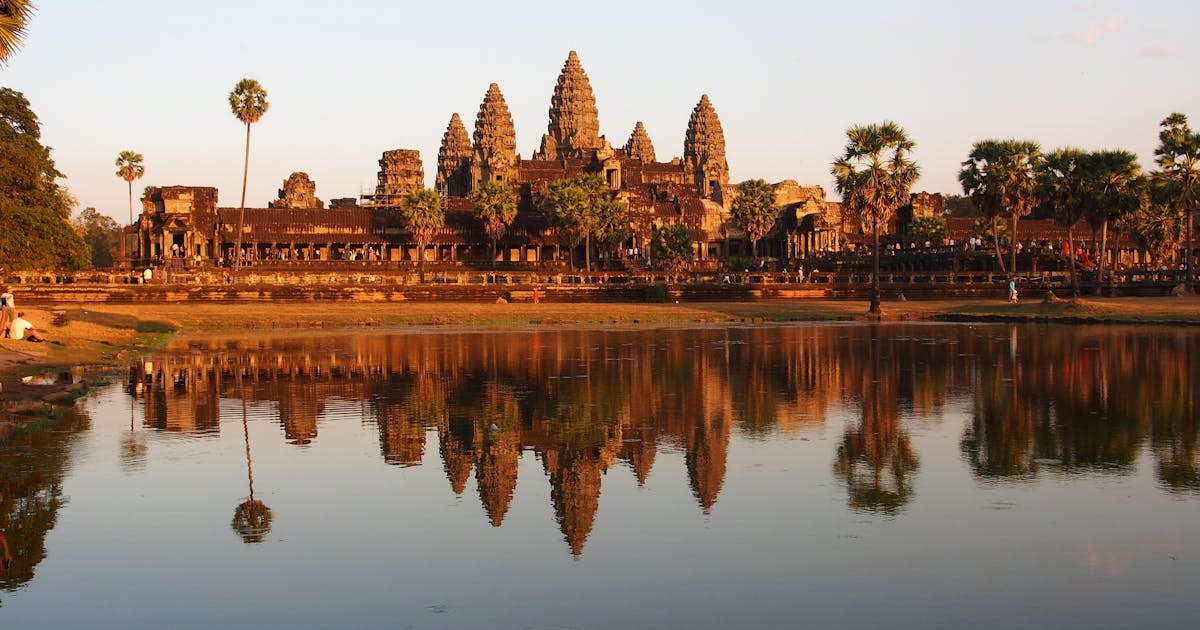 Beautiful Angkor Wat Buddhist temple is lit up by the orange sunset in Cambodia.