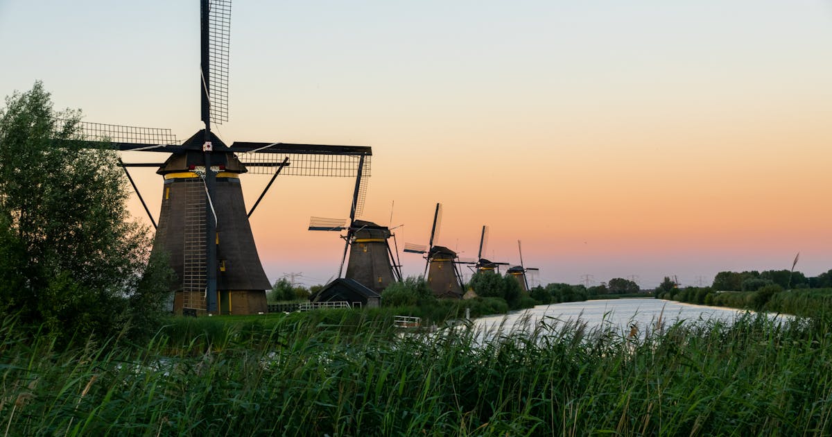 The beautiful windmills on the grass plains of Netherlands
