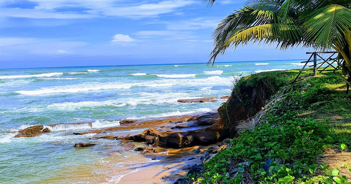 Beautiful waves crashing on the shores of Ghana on a blue cloudy day.