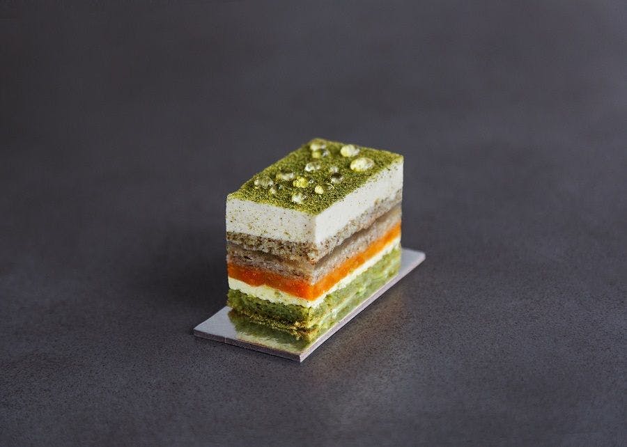 A delicate dish with multiple layers and a black background.