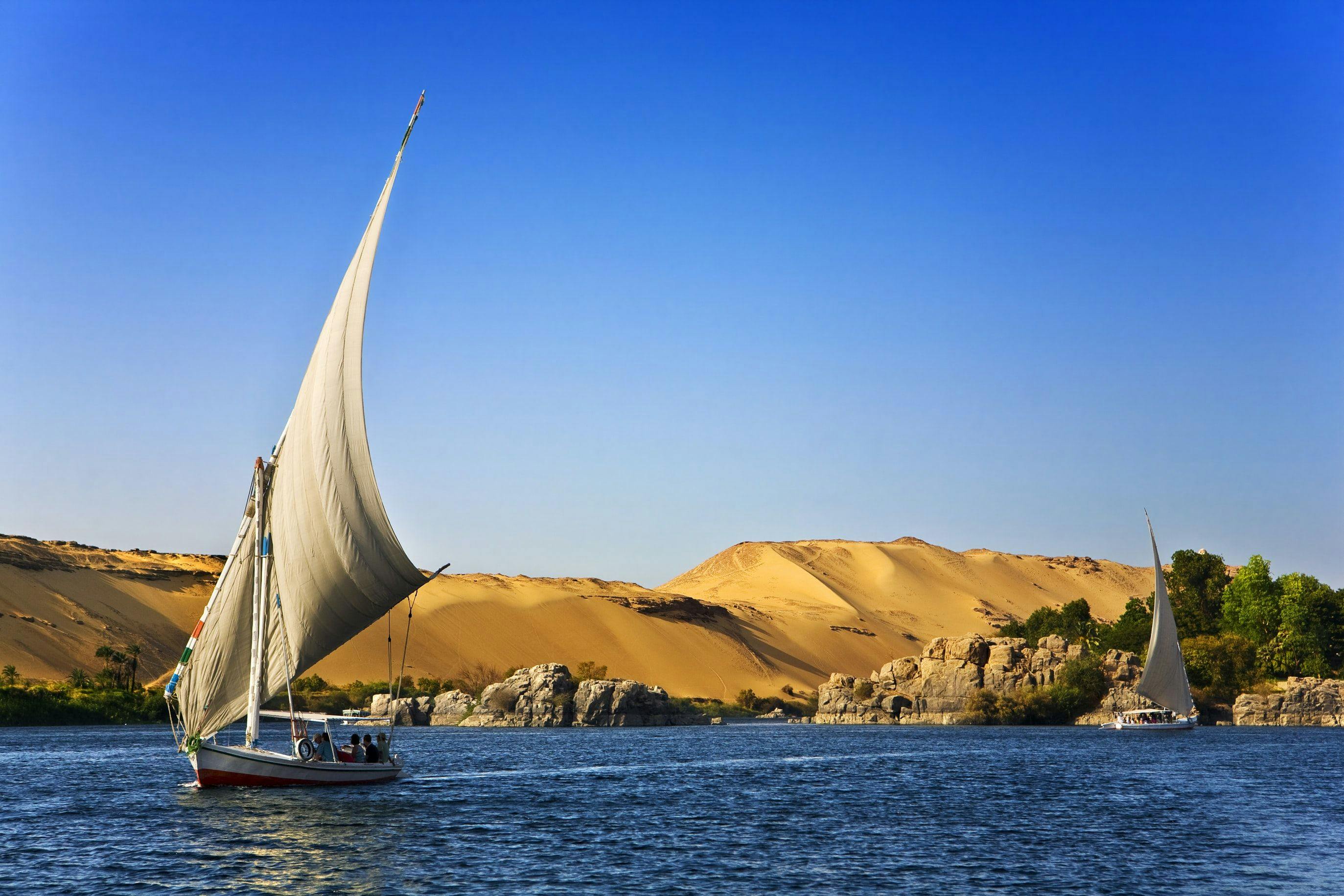 Unique boats on the ocean in Egypt. The orange desert sand can be seen in the background