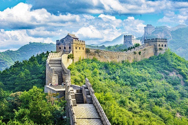 The Great Wall of China surrounded by green trees.