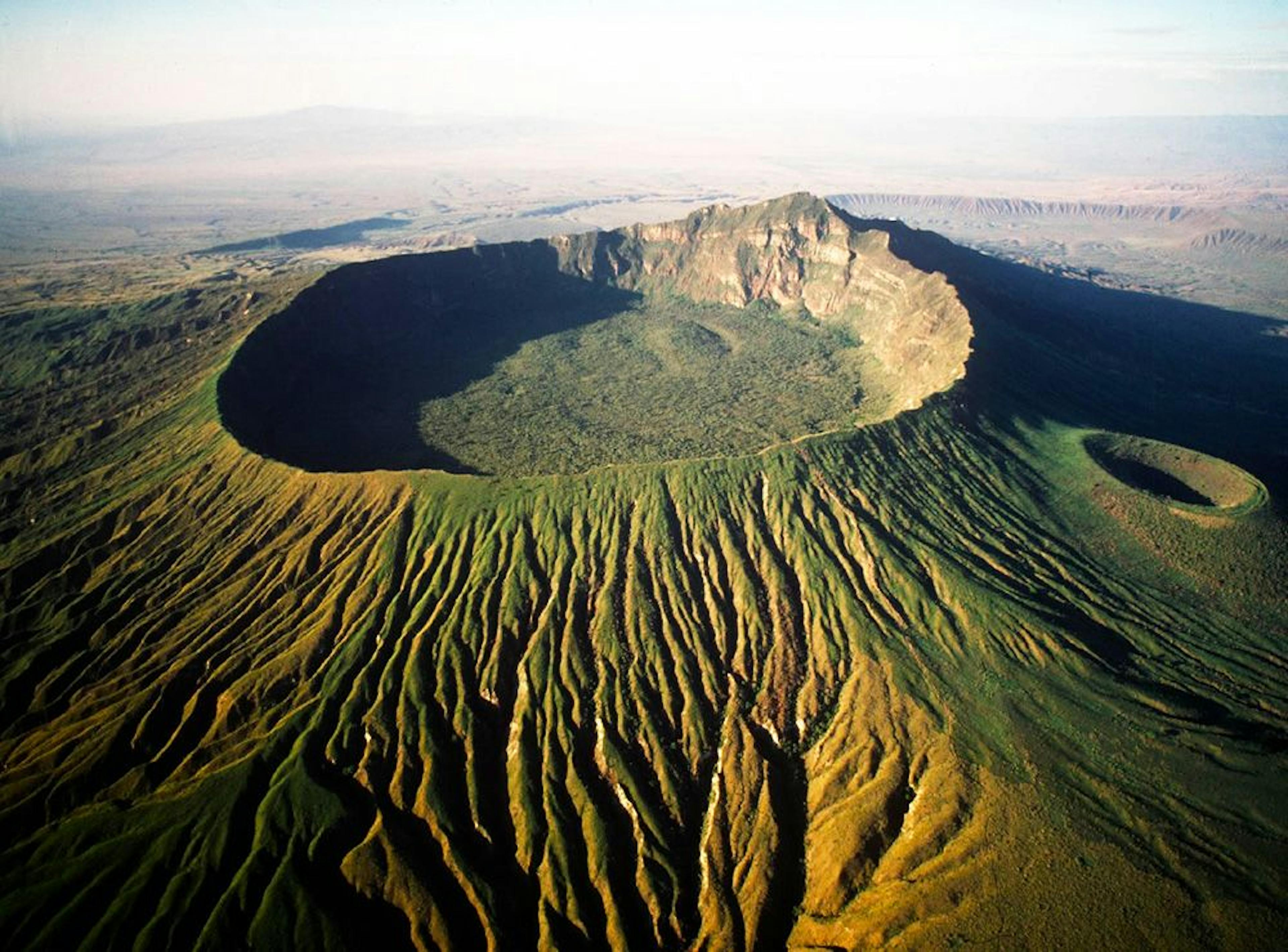 Big green mountain with a crater in the middle.