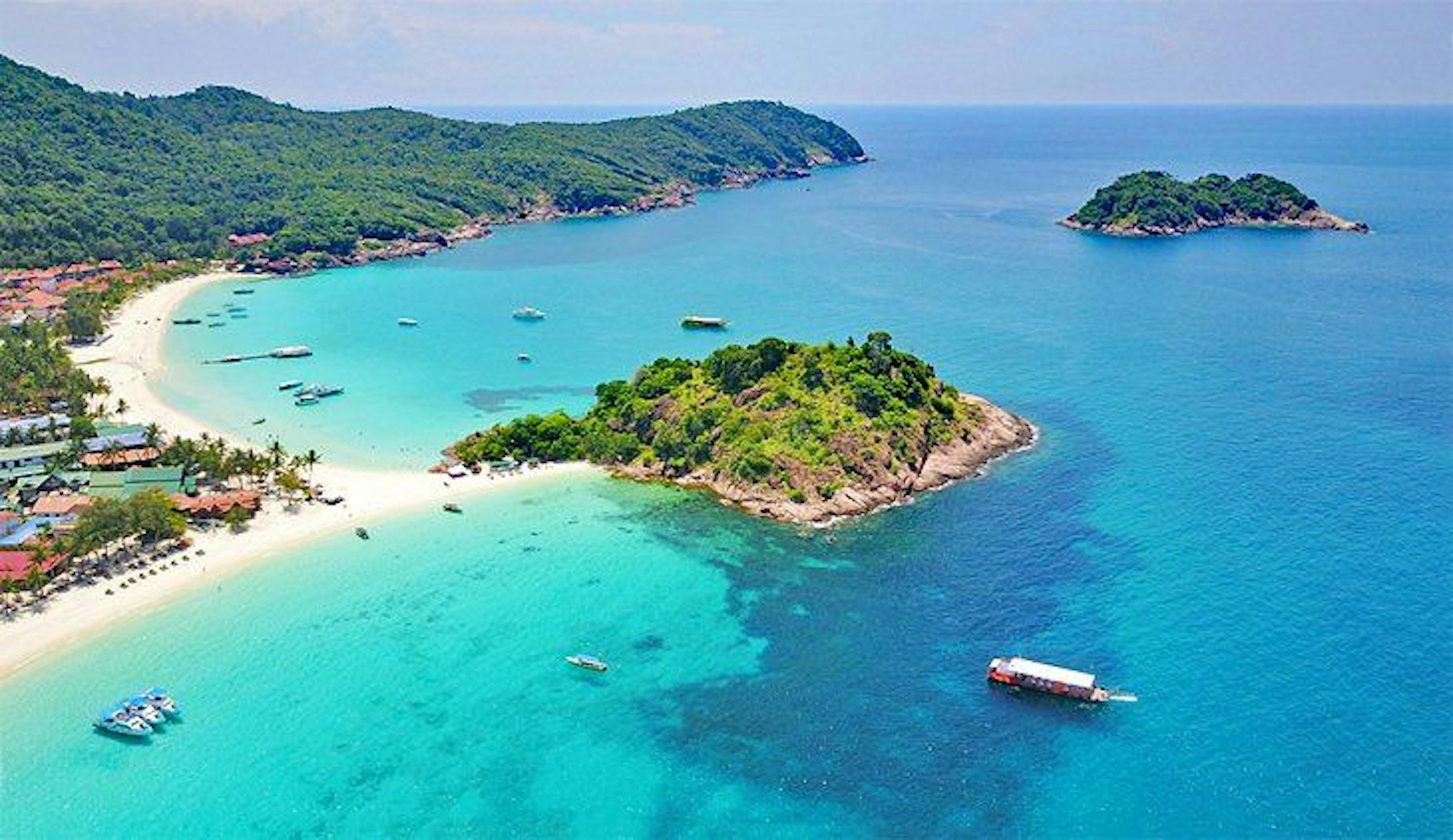 Aeriel view of an island and a coastline with clear blue waters.
