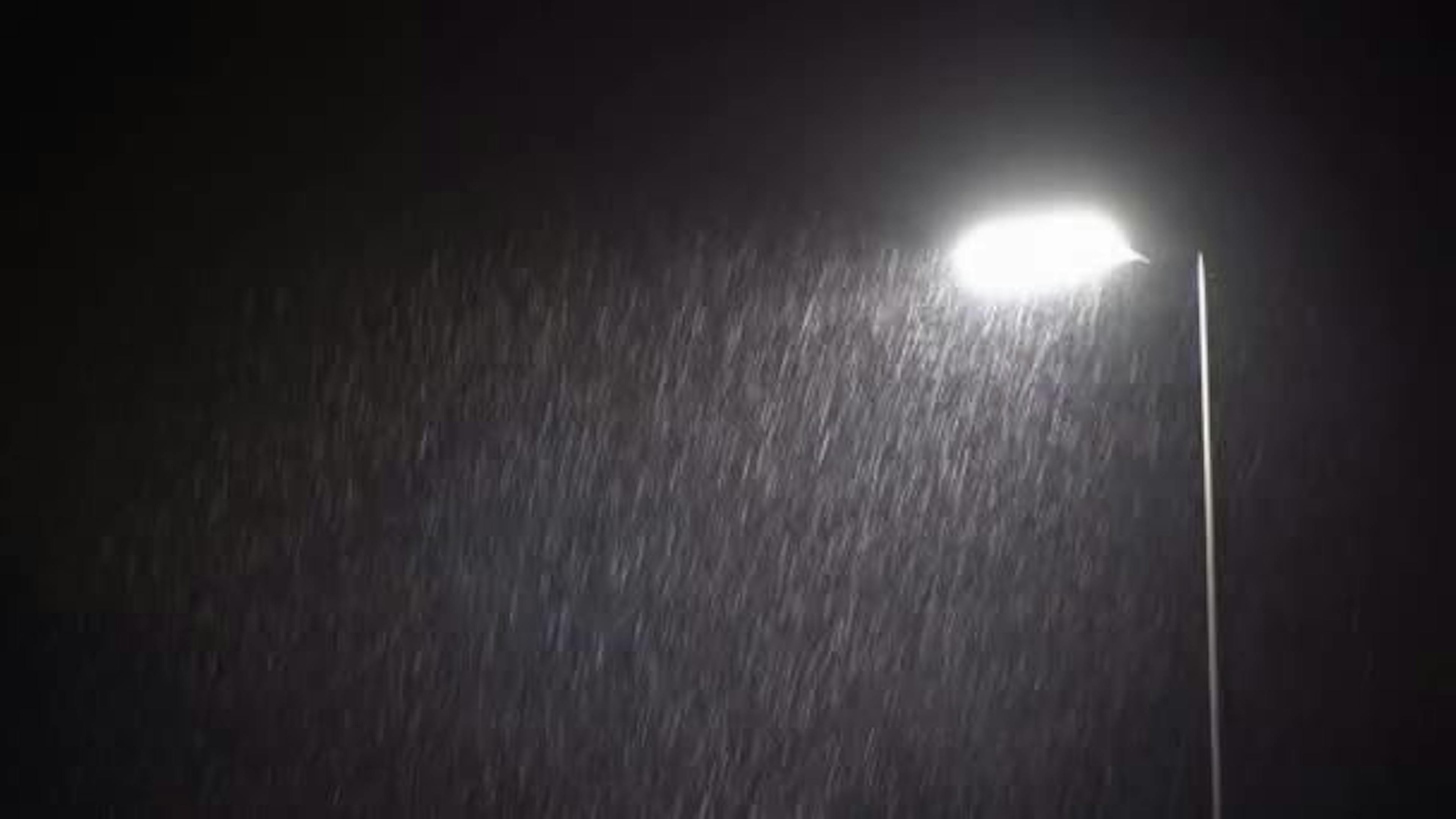 A spotlight that is lighting up raindrops.