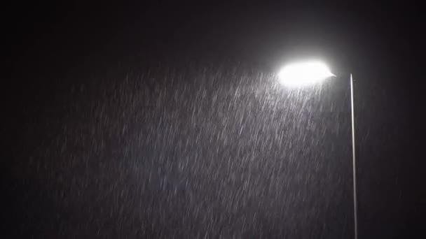 A spotlight that is lighting up raindrops.