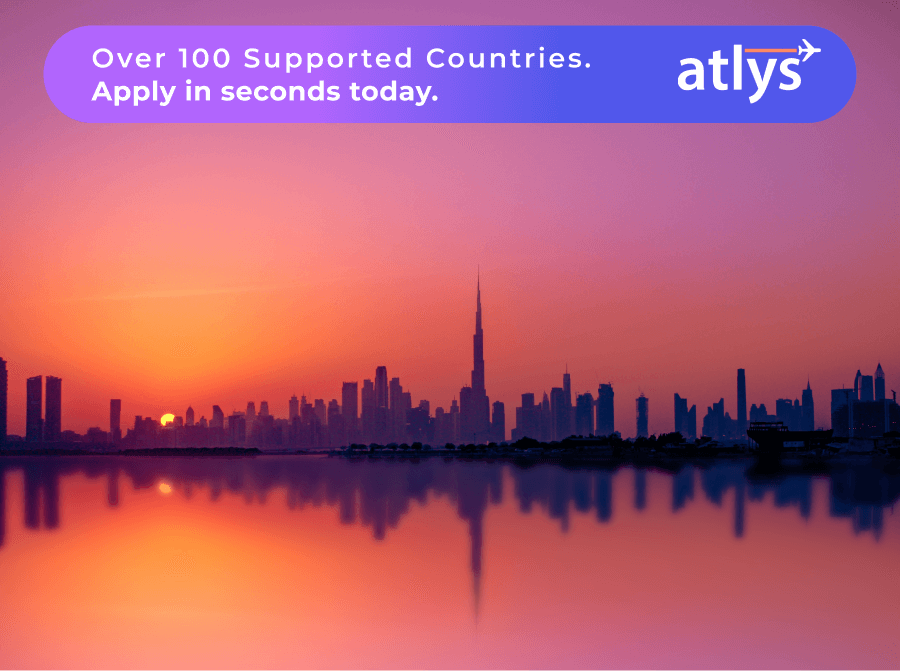 A city reflecting from a body of water with a orange an purple sky.