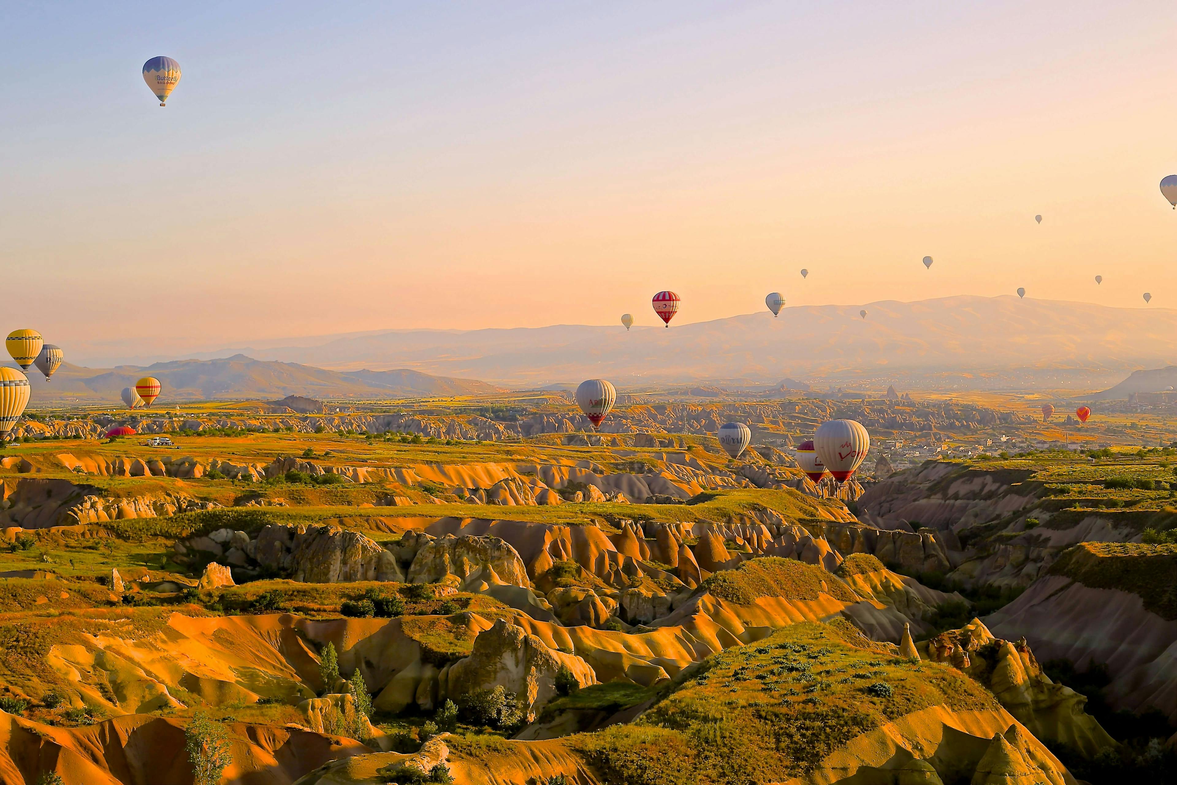 beautiful sunrise over Cappadocia, hundreds of hot air balloons can be seen in the sky