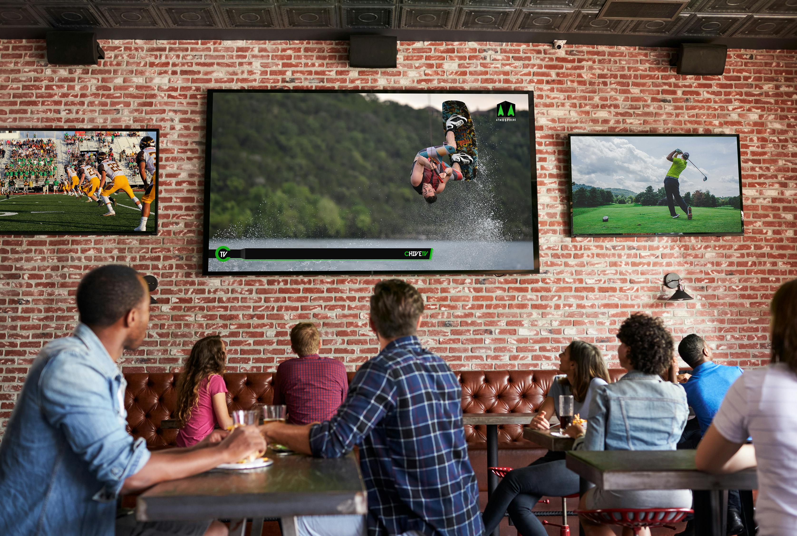 A group of customers at a restaurant enjoying Chive TV alongside live sports