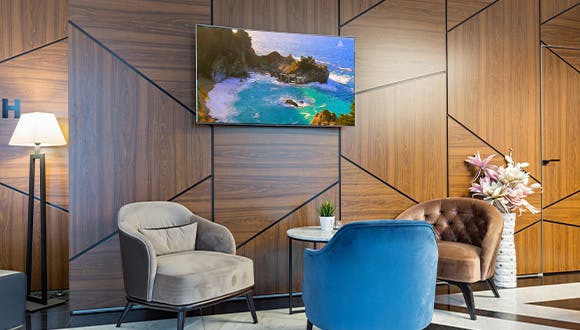 A hotel waiting area with a TV playing Escape TV on Atmosphere TV.