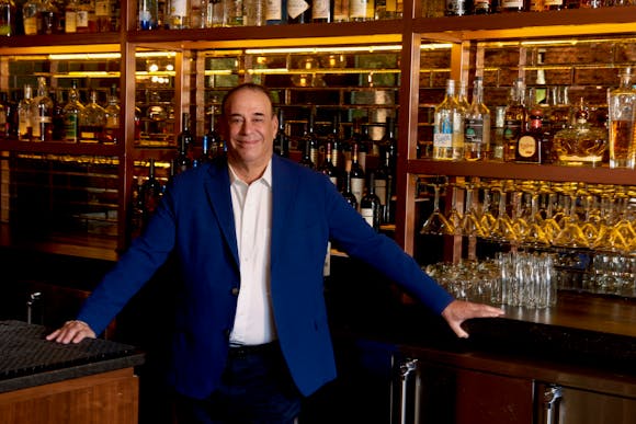 Jon Taffer in front of a bar.