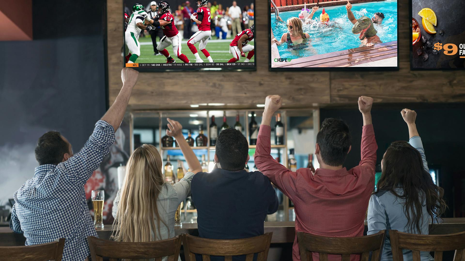 Excited customers sitting at the bar watching Atmosphere TV next to the Falcons game.