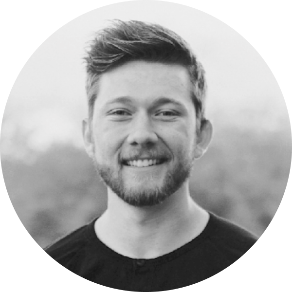 A black and white photo of Brandon Namie, he is a white man with dirty blonde, medium length hair wearing a black shirt.