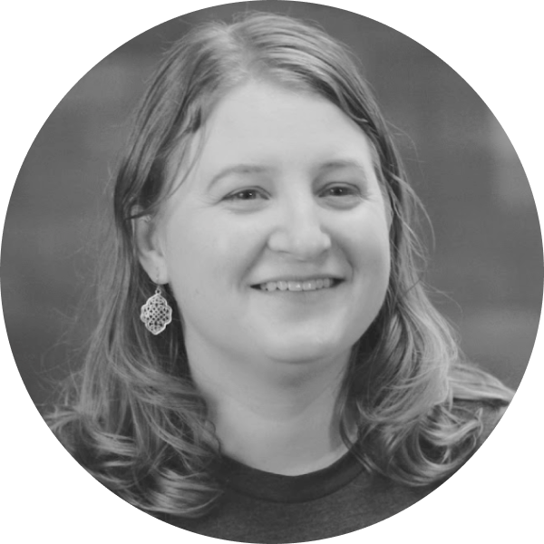 A black and white photo of Sarah Kinneer, she is a white woman shoulder length dark blonde hair smiling.