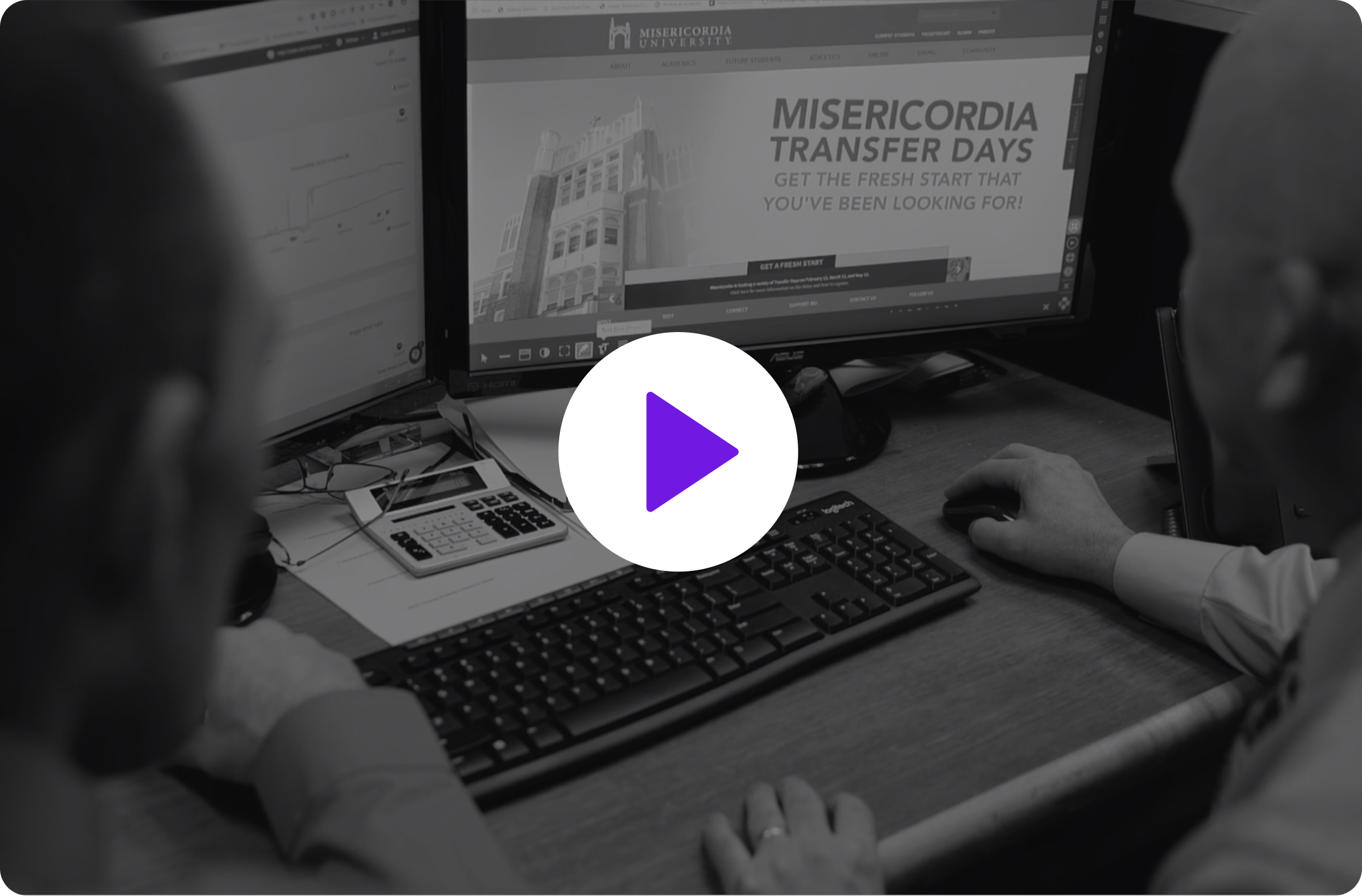 Video thumbnail of two men sitting at a computer with a play button on top of the image