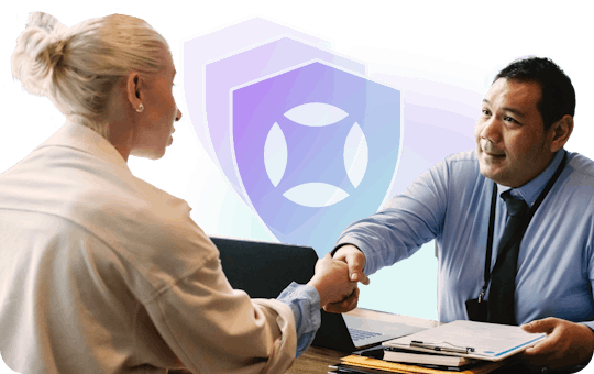 A man and a woman shaking hands at a desk. There are shields with the AudioEye logo on them floating in the background.