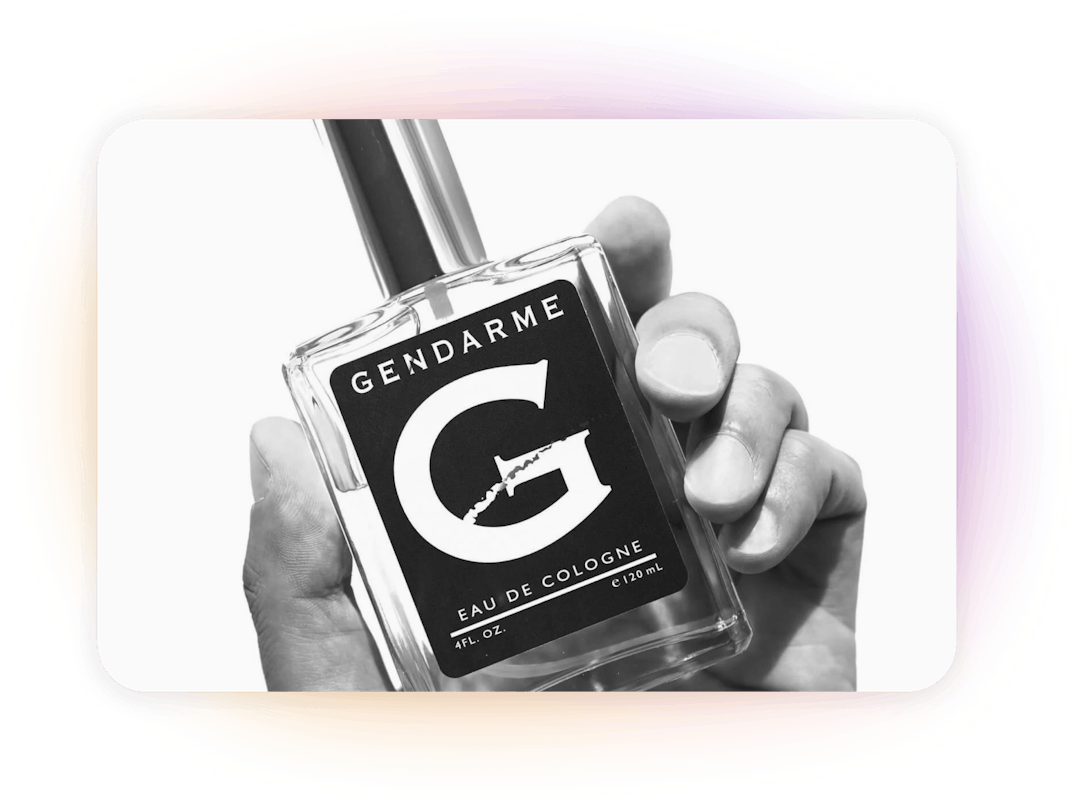 Hand holding a bottle of Gendarme cologne