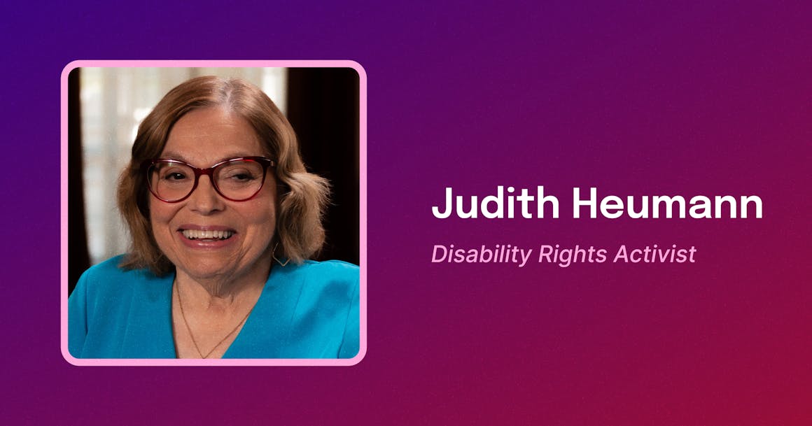 Framed photo of Judy, a white woman with shoulder length brown hair smiling, wearing a blue blouse and red-framed glasses. To the right, text reads "Judith Heumann. Disability Rights Activist."