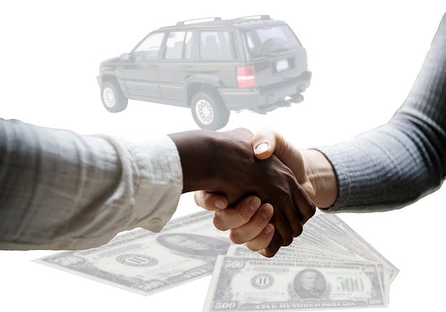 Customer shaking hands with dealership salesperson