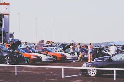 Cars with hoods open at an outdoor show