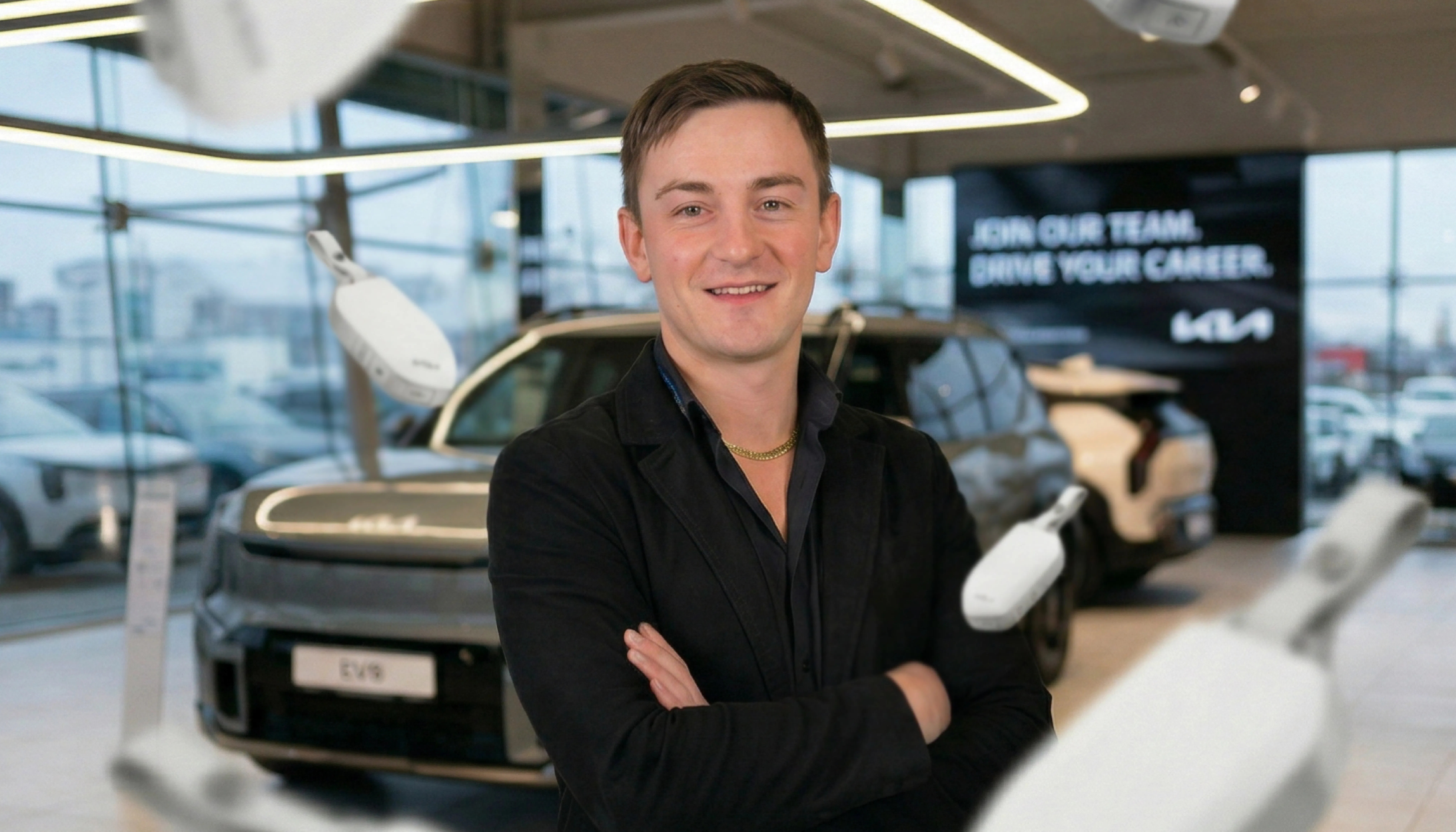 Autmobilverkäufer gesucht | Autohaus Range | Tobias vor einem Kia EV9