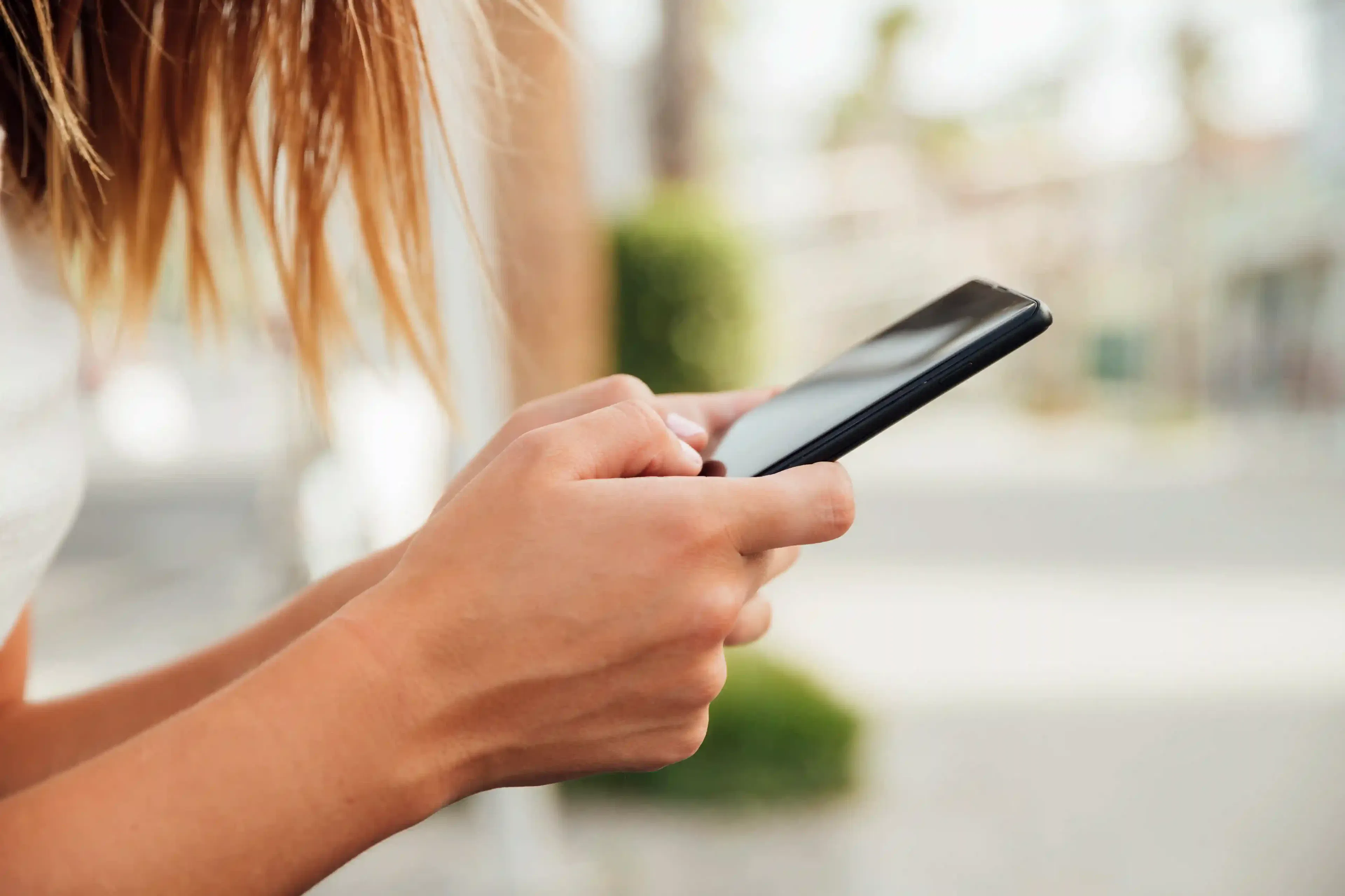 young woman holding black smartphone for Android app