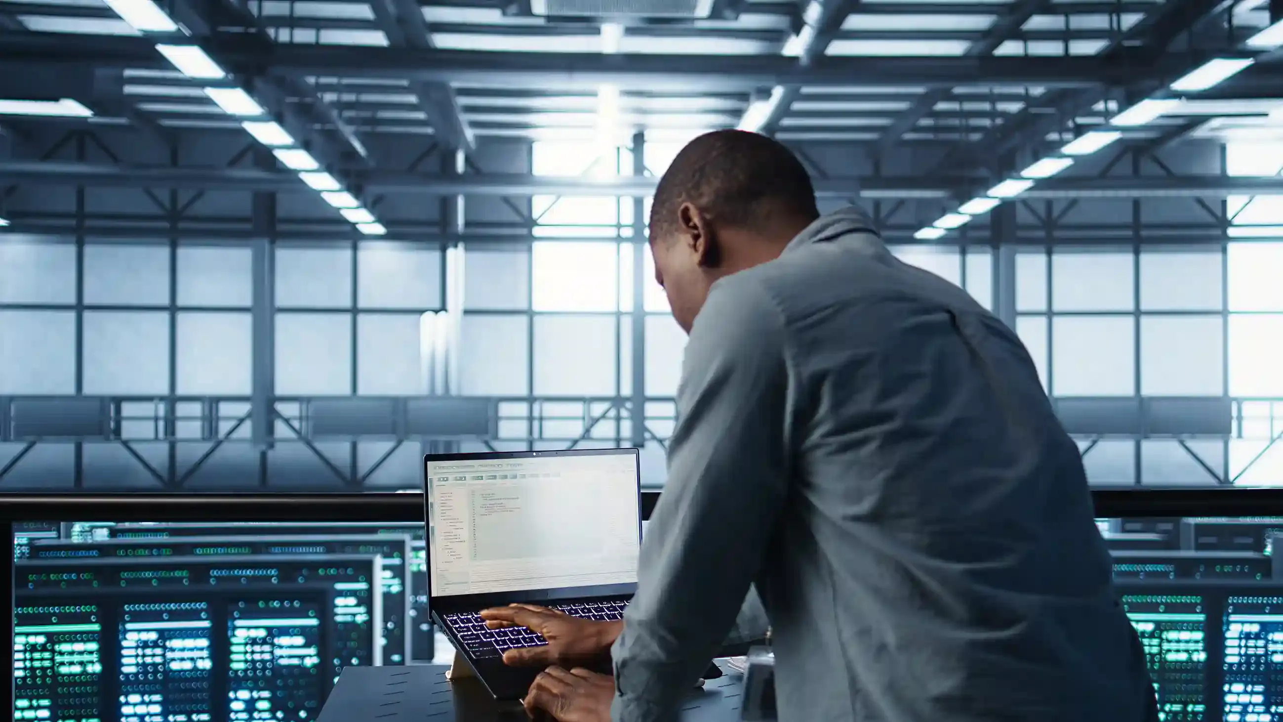 data center engineer coding on laptop to optimize resources