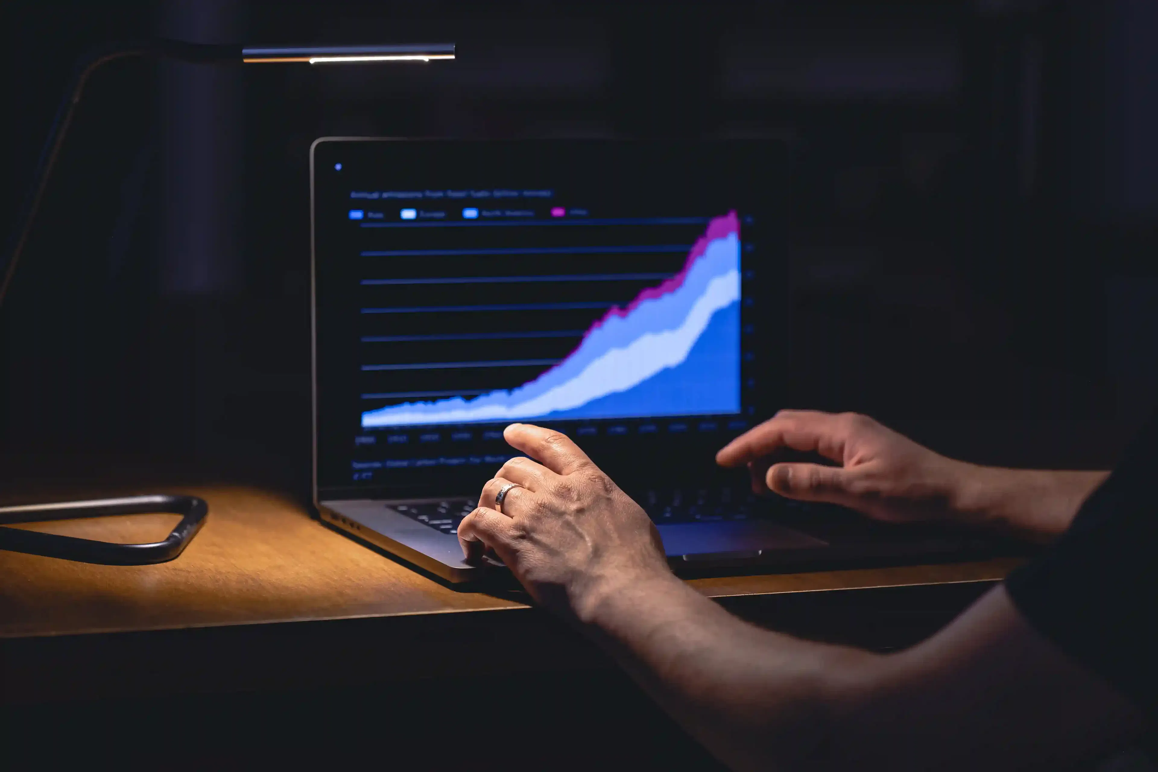 business analyst viewing data on laptop screen at night