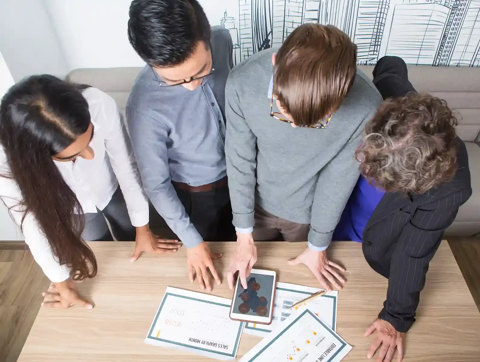 four business colleagues discussing technical diagrams