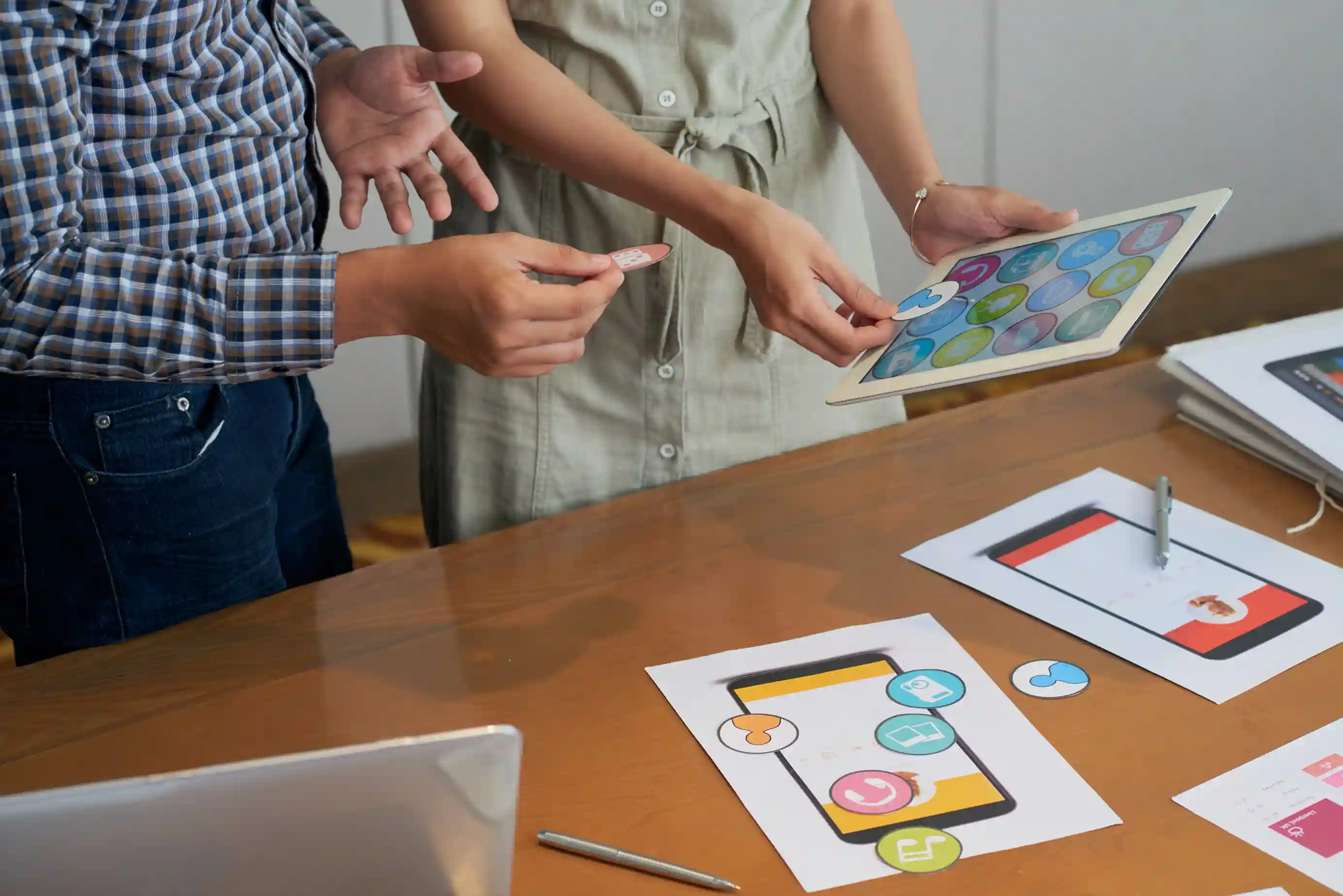 unrecognizable colleagues testing app icons on tablet