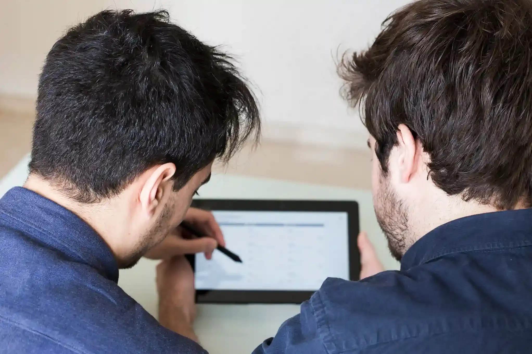 man discussing remote software development data on tablet device