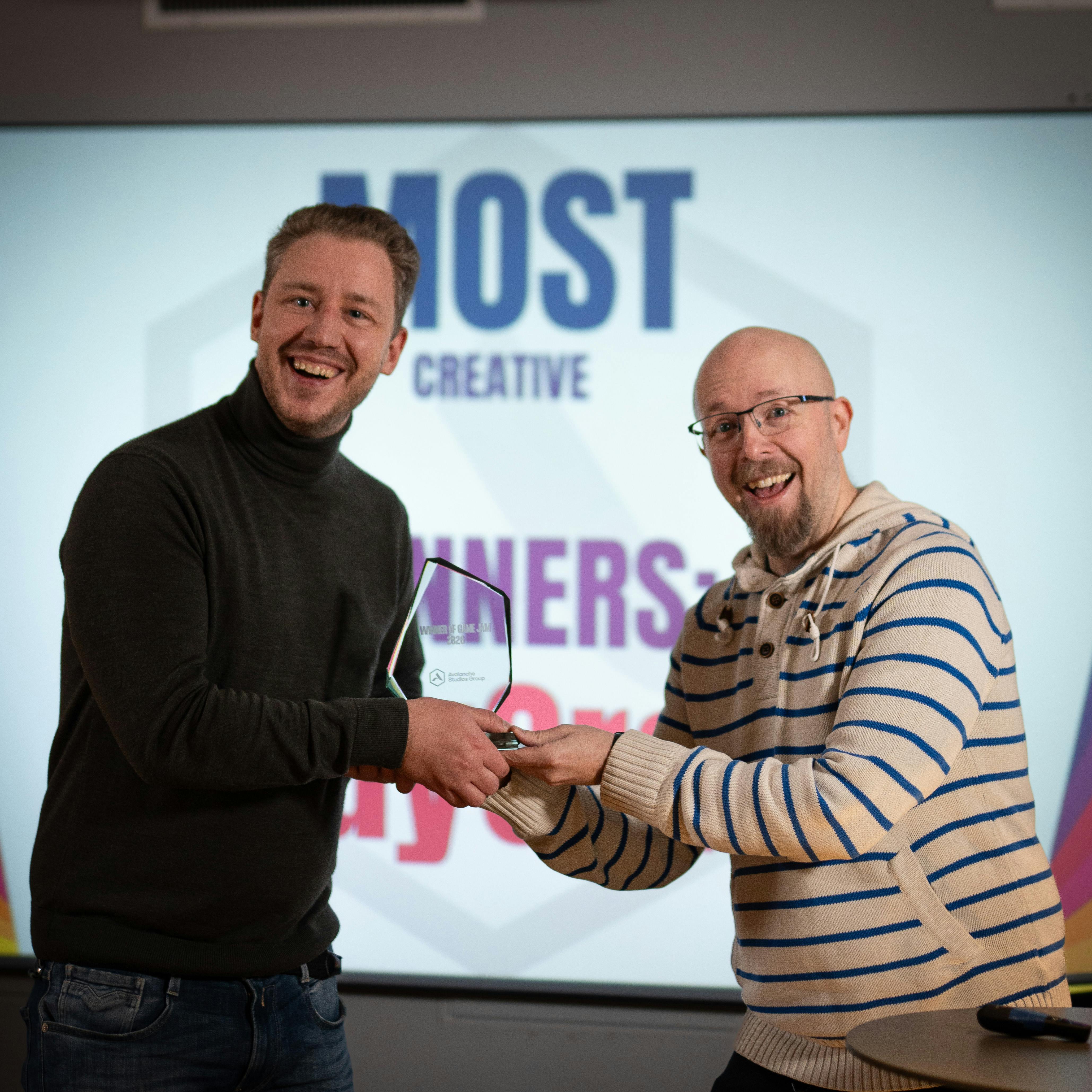 Team members standing together as one presents an award to another.