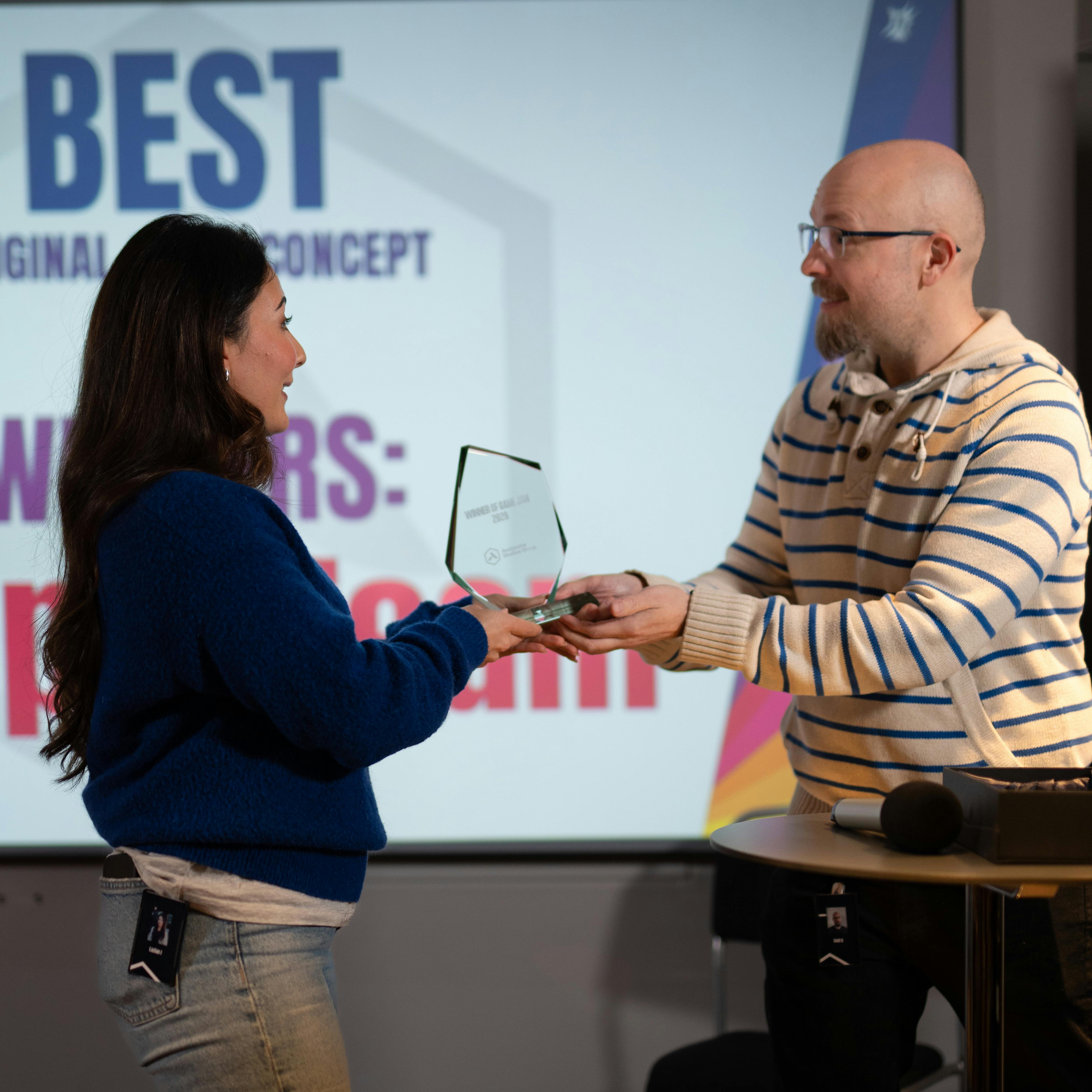 A team member giving an award to a colleague.
