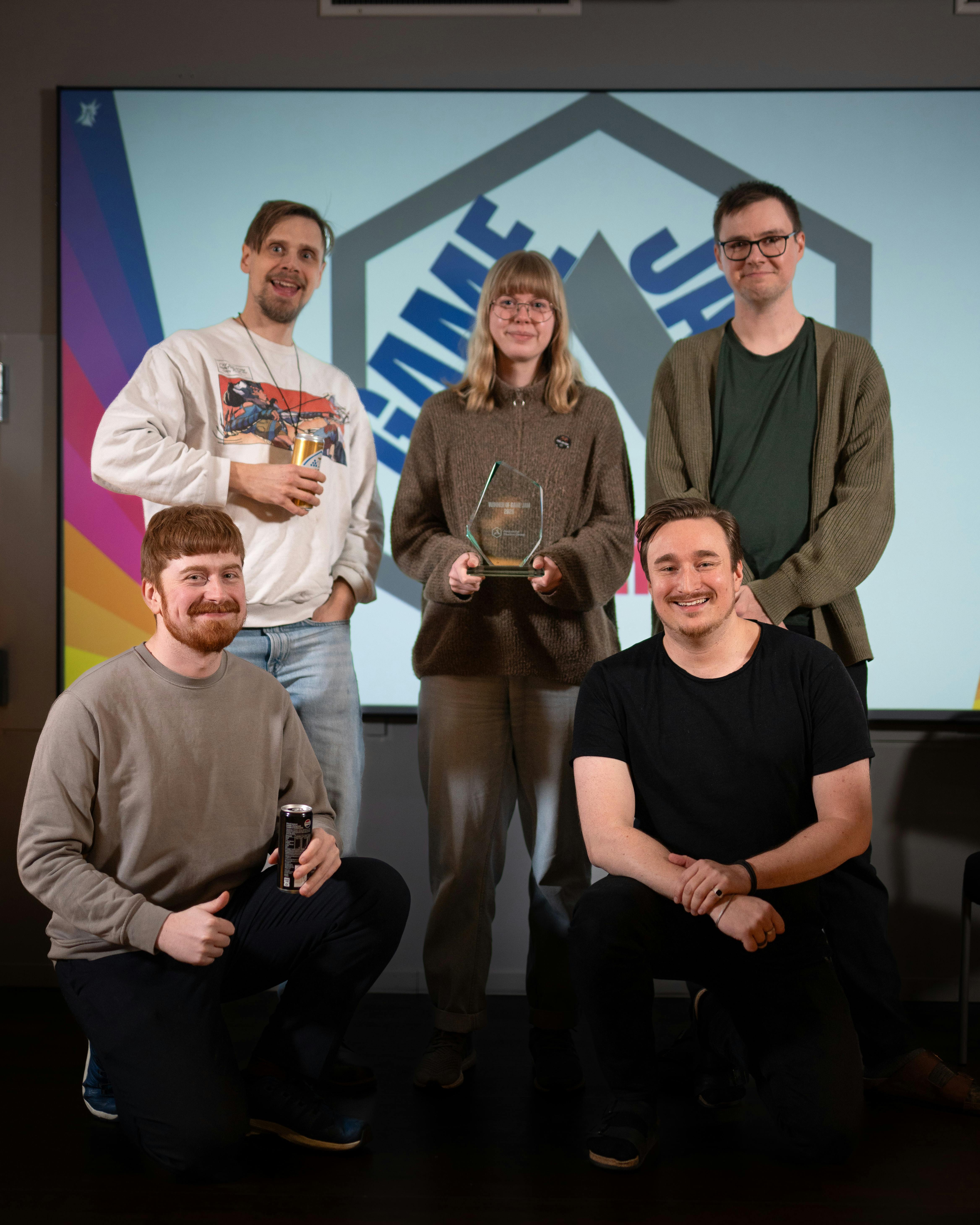Five team members standing together, each holding an award.