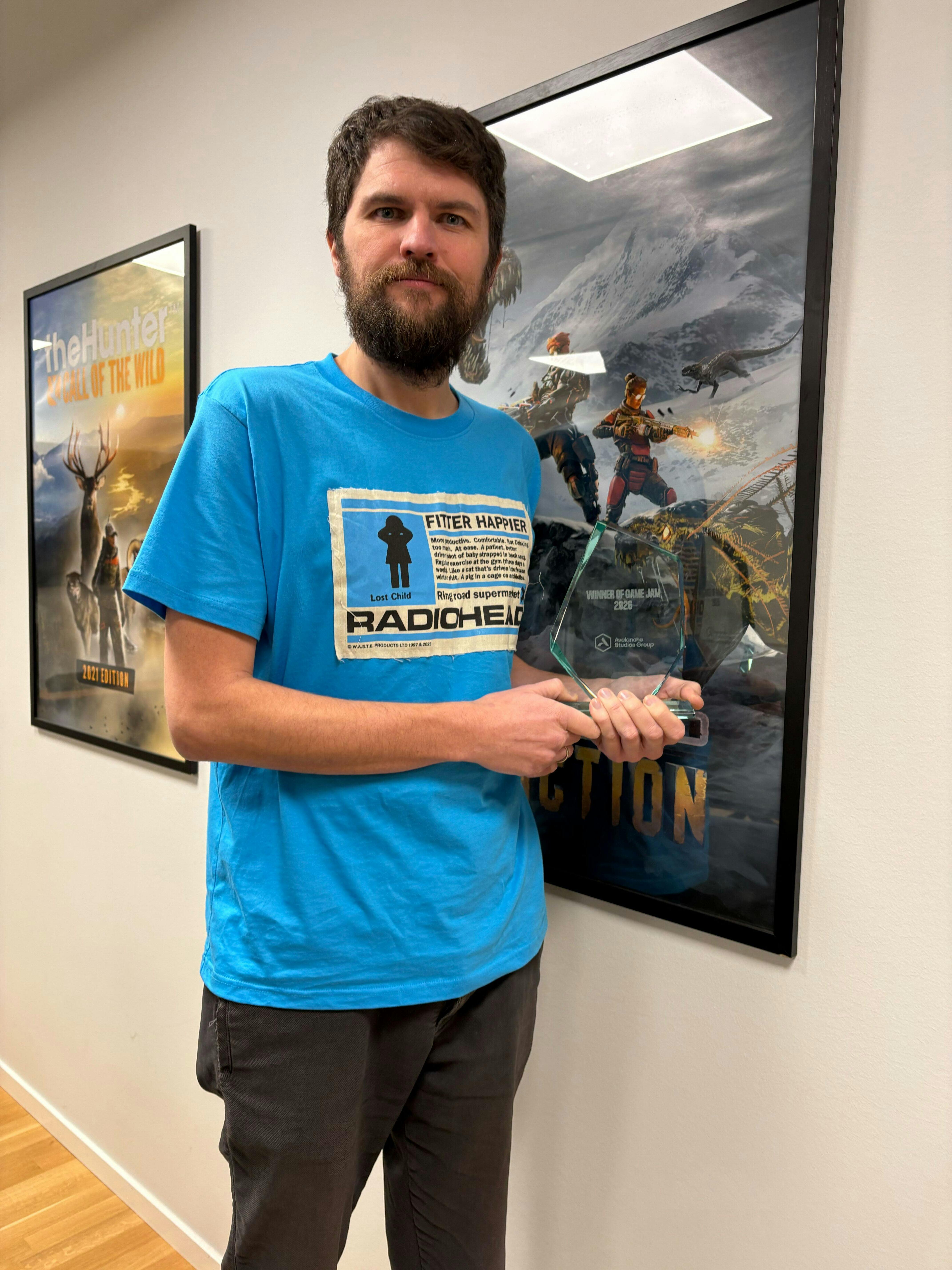 A team member holding a trophy and posing for a photo.