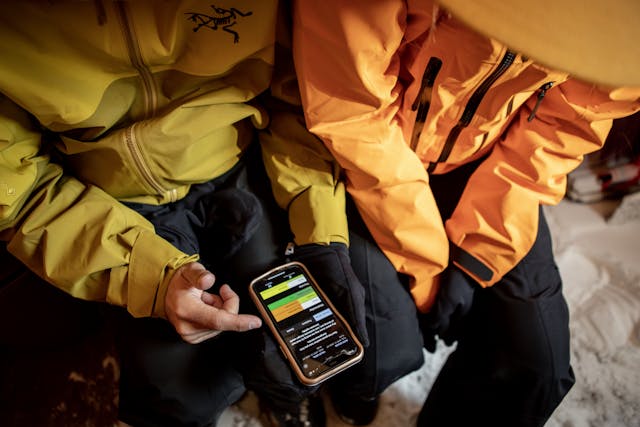 Two people looking at the avalanche forecast on a mobile phone