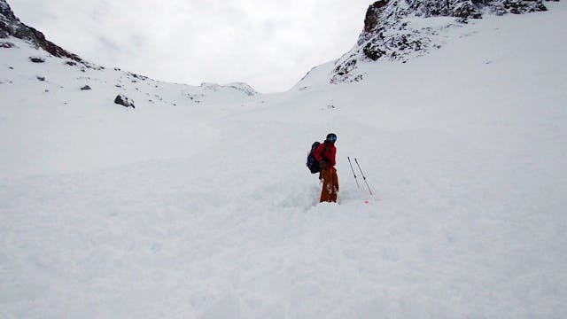 A skier standing in avalanche debris.