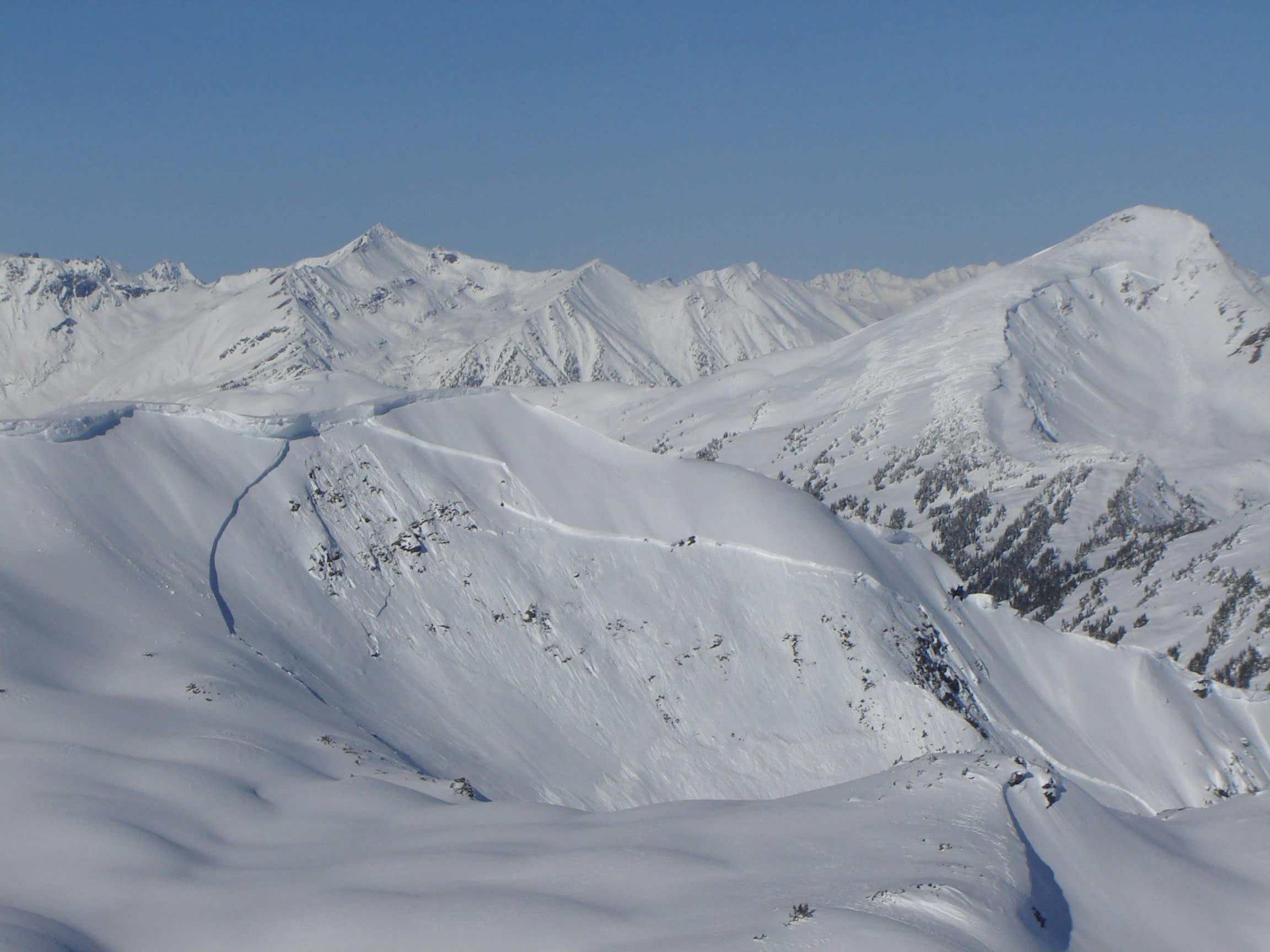 A large avalanche crown covers most of an alpine bowl. 