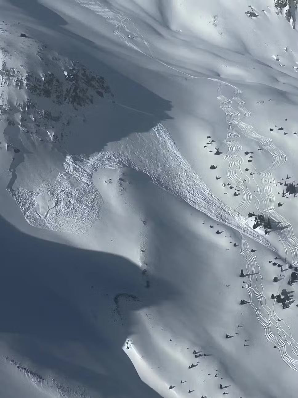 a set of skier tracks partially covered by an avalanche